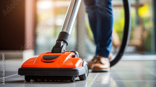 A person cleaning carpet with vacuum cleaner. Close up head of a sweeper cleaning device.