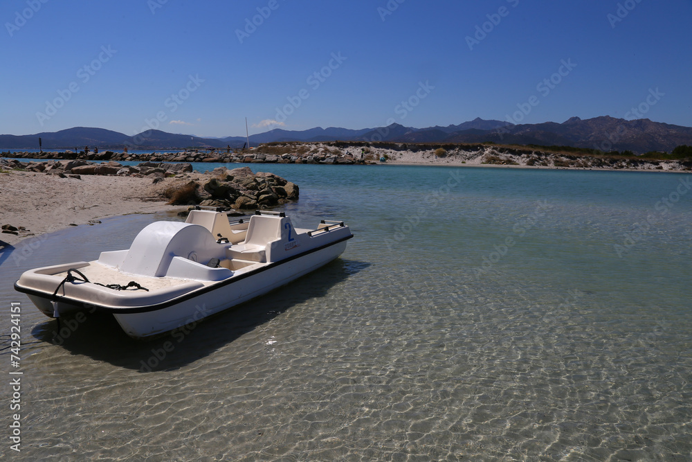 White pedal boat in Puntaldia beach and La Cinta beach in San Teodoro, Sardinia, Italy