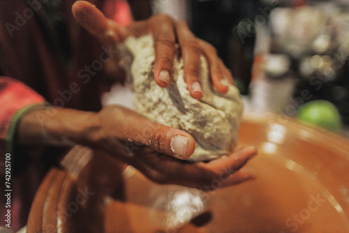 Hands knead dough