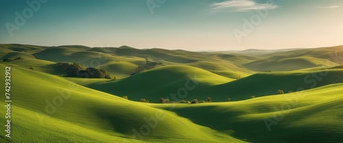 Idyllic Rolling Green Hills Under a Clear Blue Sky with Wispy Clouds. Tranquil Nature Landscape