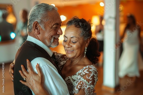 Amidst the elegant indoor wedding reception, a man and woman share a passionate kiss while dancing in their wedding attire, radiating love and joy as they celebrate their marriage