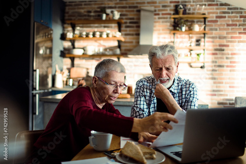 Senior partners discussing bills at home