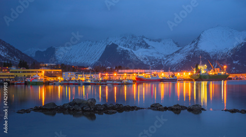 View of a small town with harbour with boats and mountain in background, Lofoten Islands, Norway. photo