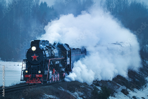 View of a steam locomotive train crossing the forest in winter, Ruskeala Express, Republic of Karelia, Russia.
