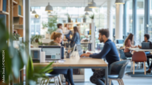 Fotografía Blurred photo capturing the dynamic atmosphere of a modern open-plan office with people engaged in discussion and work