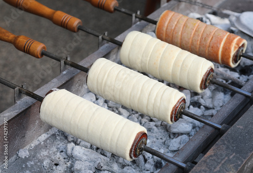 Trdelník also called trozkol is a kind of spit cake of East Europe slow cooked over glowing embers and served hot with grains of dried fruit photo