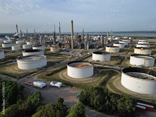 Aerial view of UK oil refinery and oil storage tanks in Fawley, Hampshire. White oli storage tanks and petrochemical complex with chimneys. photo