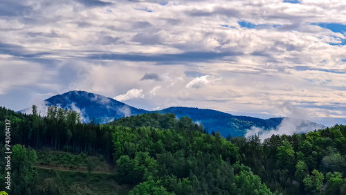 Idyllic hiking trail through lush green forest in Grazer Bergland, Prealps East of the Mur, Styria, Austria. Scenic view of mountain Schöckl. Soft hills in alpine landscape. Wanderlust photo