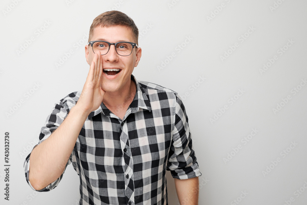 Portrait of handsome man shouting loudly with hands, news, palms folded like megaphone isolated on white background Portrait of handsome man shouting loudly with hands, news, palms folded like megaphone isolated on white background