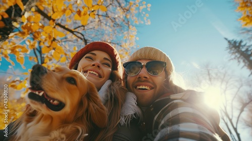 Romantic happy couple enjoying time with dog in nature in the park. photo