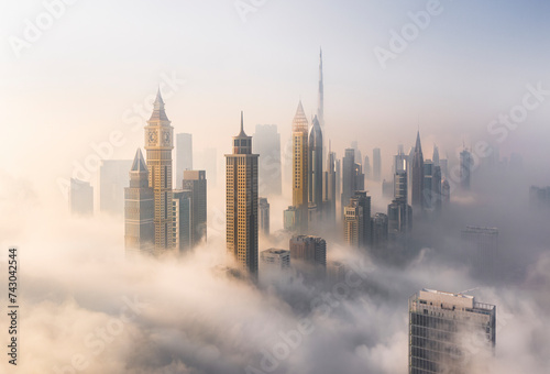 Aerial view of Burj Khalifa and Downtown Dubai surrounded by hazy clouds, Dubai, United Arab Emirates. photo