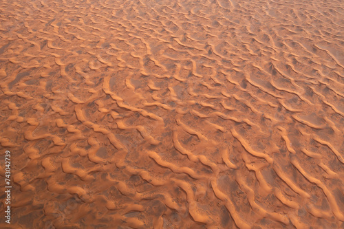 Aerial view of endless desert landscape with warm orange sand dunes, Sharjah, United Arab Emirates.