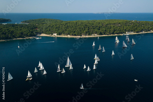 Aerial view of sailing boats for a regatta along the coastline in Zara with beautiful Adriatic coastline and turquoise sea, Croatia. photo