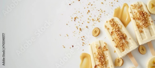 Peanut butter banana popsicles with sprinkles of peanuts and drizzle of raw peanut butter on top above view. with copy space image. Place for adding text or design photo