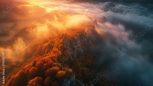 Aerial View of a Lush Mountain Peak Piercing Through Mist at Sunset in Slovenia © bomoge.pl