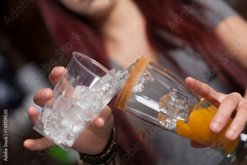 Bartender pouring ice in a cocktail