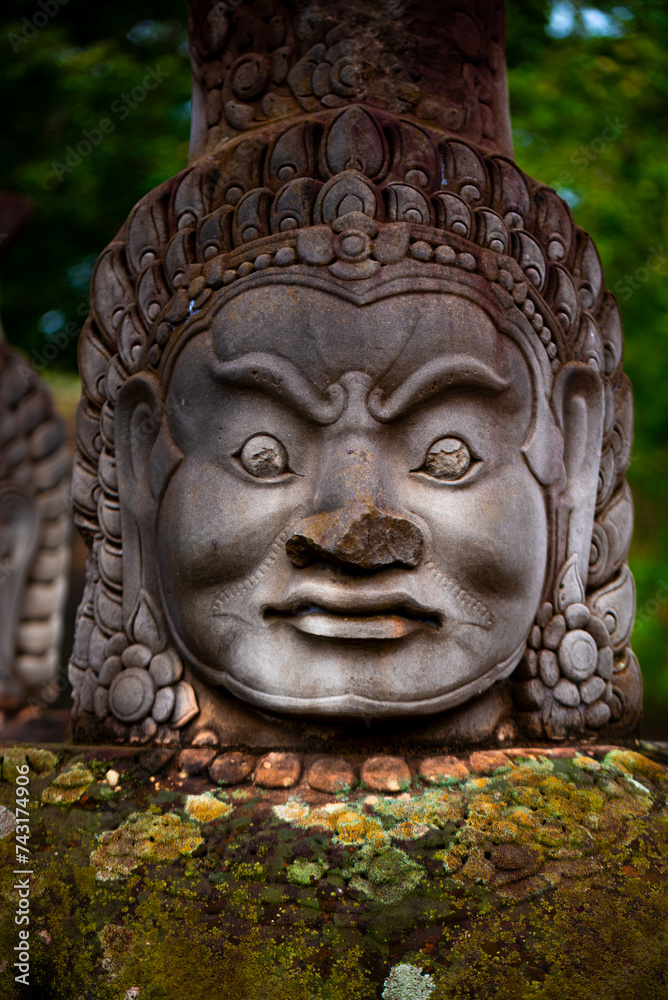 Close up of a statue smiling face on South Bridge to Entrance of Angkor Thom, Khmer styled Temple, Siem Reap,Angkor Area, Cambodia.