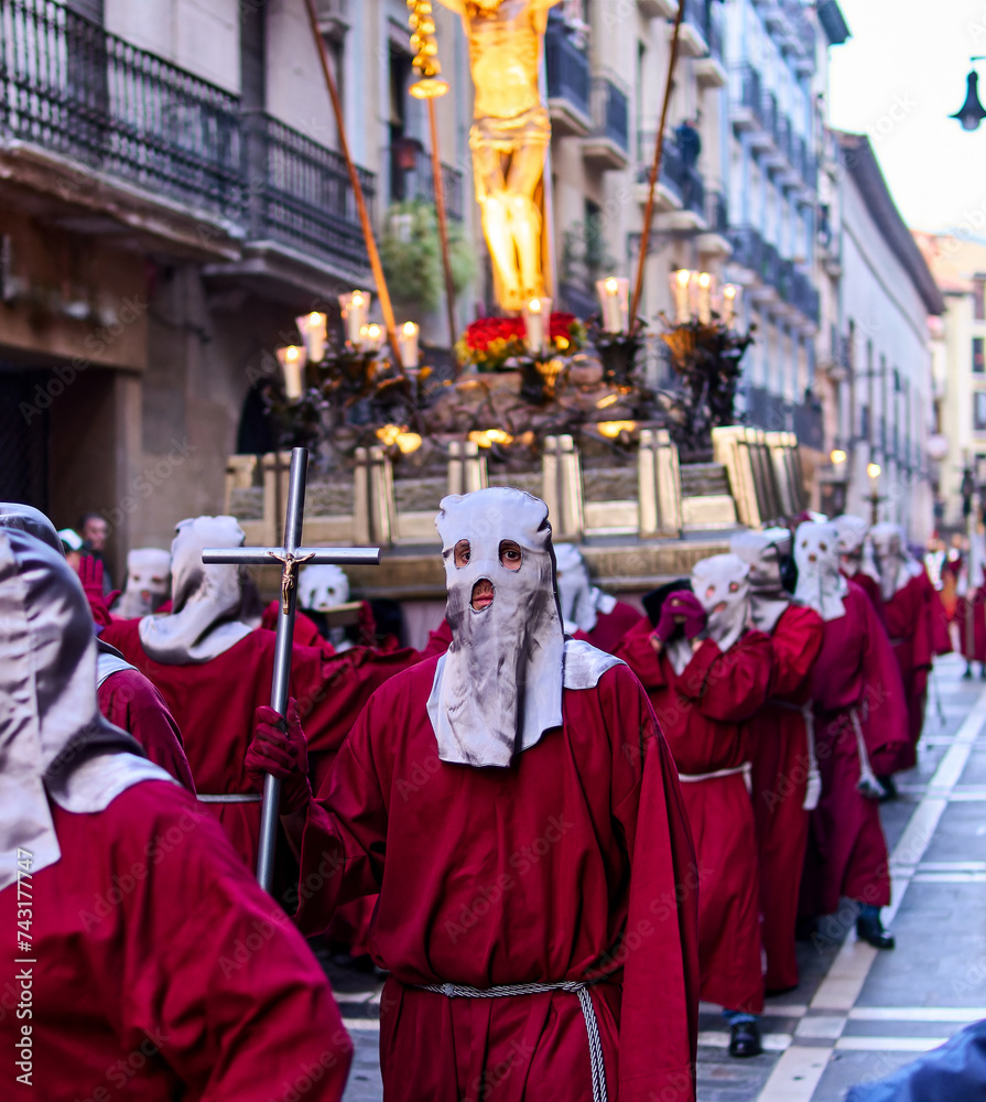 Naklejka premium Procession of Individuals in Red Robes and White Masks