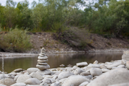 Obraz na płótnie Amazing round stone near a flowing river, Stones are perfectly balanced on one another and forming, These are river stones, or also buddha stones w salonie