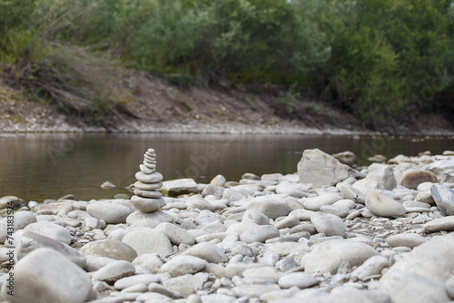 Obraz na płótnie Amazing round stone near a flowing river, Stones are perfectly balanced on one another and forming, These are river stones, or also buddha stones w salonie