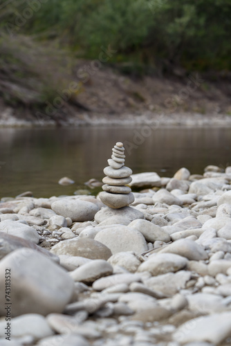 Obraz na płótnie Amazing round stone near a flowing river, Stones are perfectly balanced on one another and forming, These are river stones, or also buddha stones w salonie