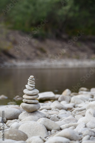Obraz na płótnie Amazing round stone near a flowing river, Stones are perfectly balanced on one another and forming, These are river stones, or also buddha stones w salonie