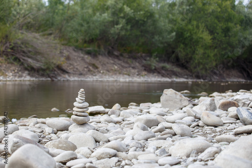 Obraz na płótnie Amazing round stone near a flowing river, Stones are perfectly balanced on one another and forming, These are river stones, or also buddha stones w salonie