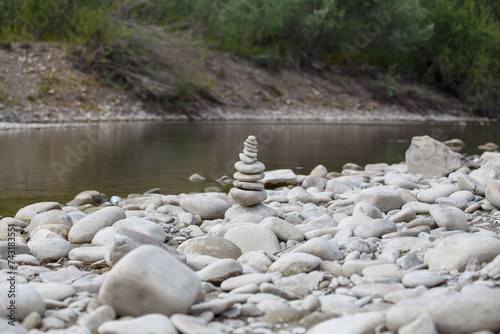 Obraz na płótnie Amazing round stone near a flowing river, Stones are perfectly balanced on one another and forming, These are river stones, or also buddha stones w salonie