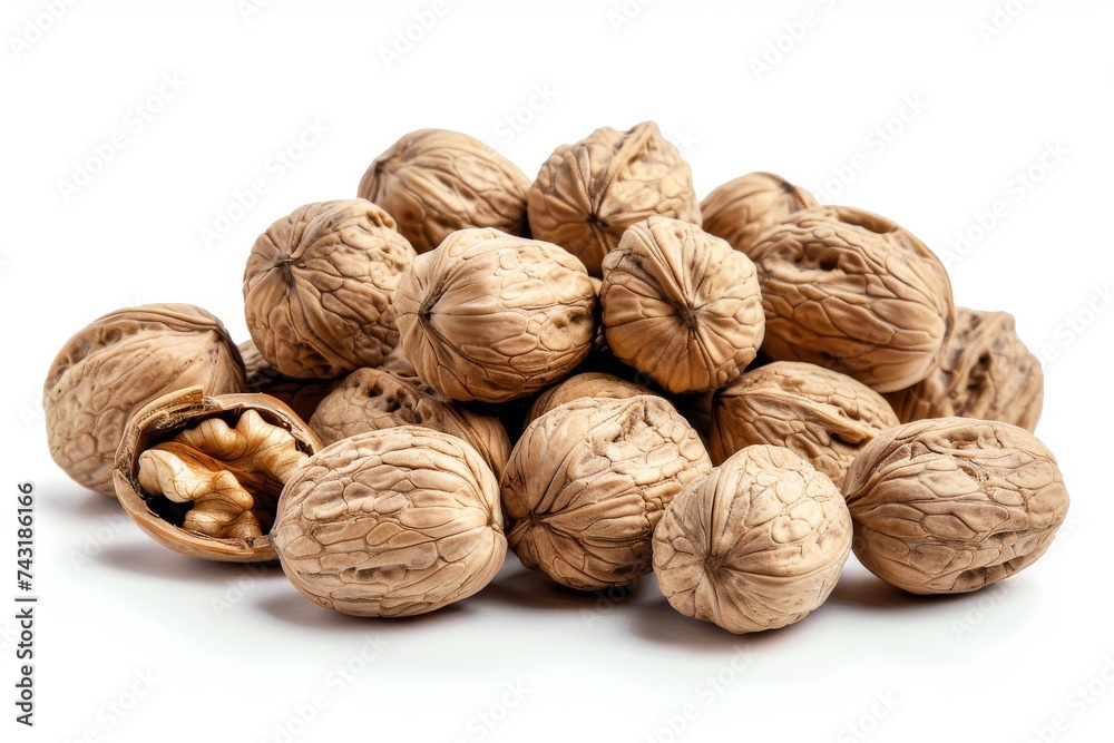 A pile of whole and cracked walnuts on a white background. A pile of whole and cracked walnuts on a white background.