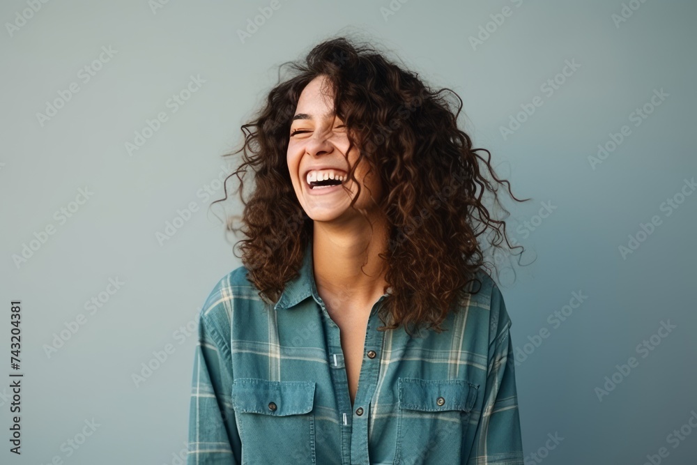 Portrait of a beautiful young woman laughing against a blue background. Portrait of a beautiful young woman laughing against a blue background.