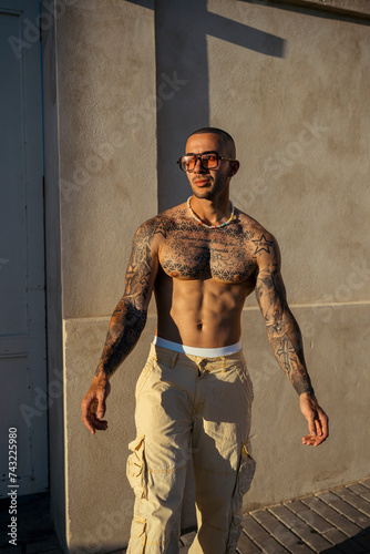 Chico joven musculoso y tatuado posando isn camiseta en la playa y en la calle © MiguelAngelJunquera