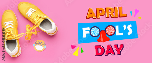 Sneakers with tied shoe laces and paper smile on pink background. April Fools' Day celebration