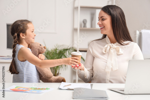 Little girl giving cup of c...