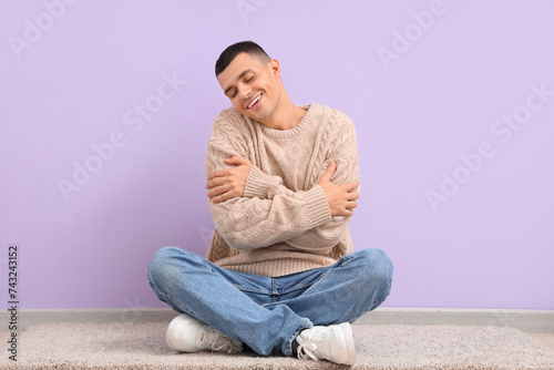 Young man hugging himself n...