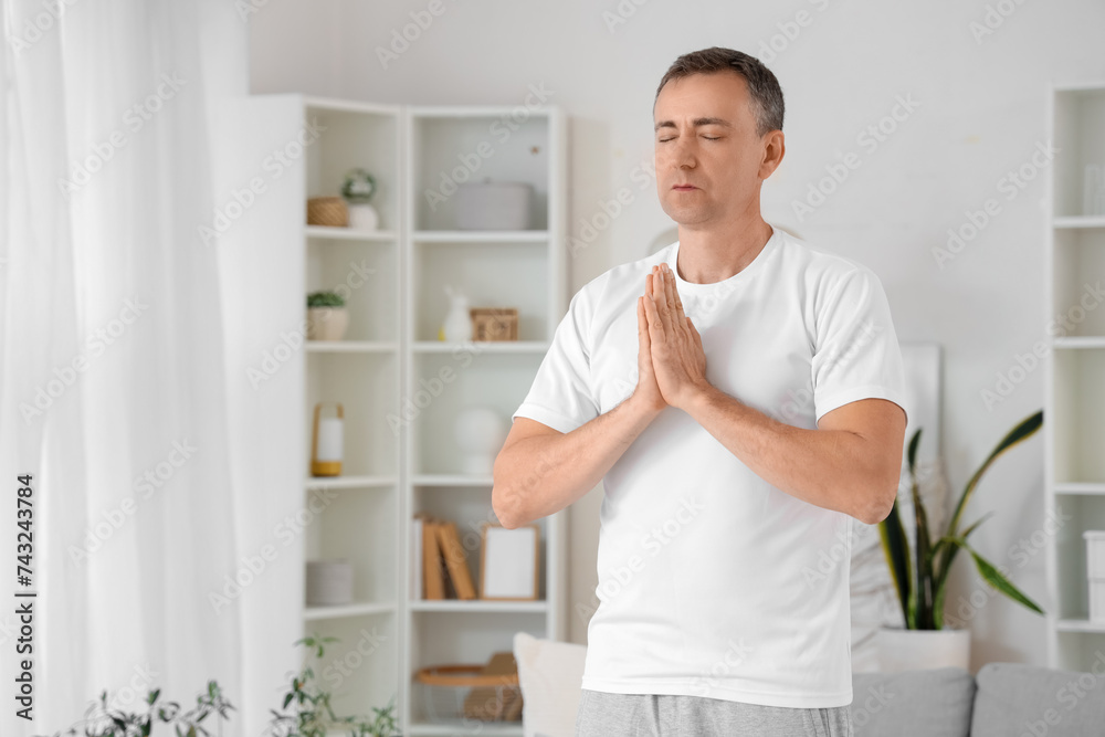 Mature man meditating at home Mature man meditating at home