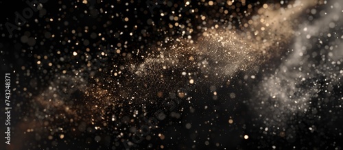 Snowflakes are shown falling in a blurred motion against a stark black backdrop, creating an abstract and dynamic visual effect.