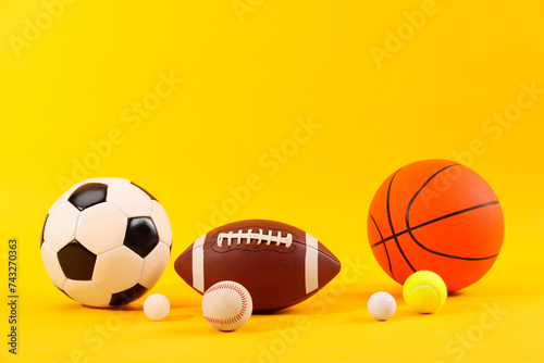 Many different sports balls on yellow background  space for text
