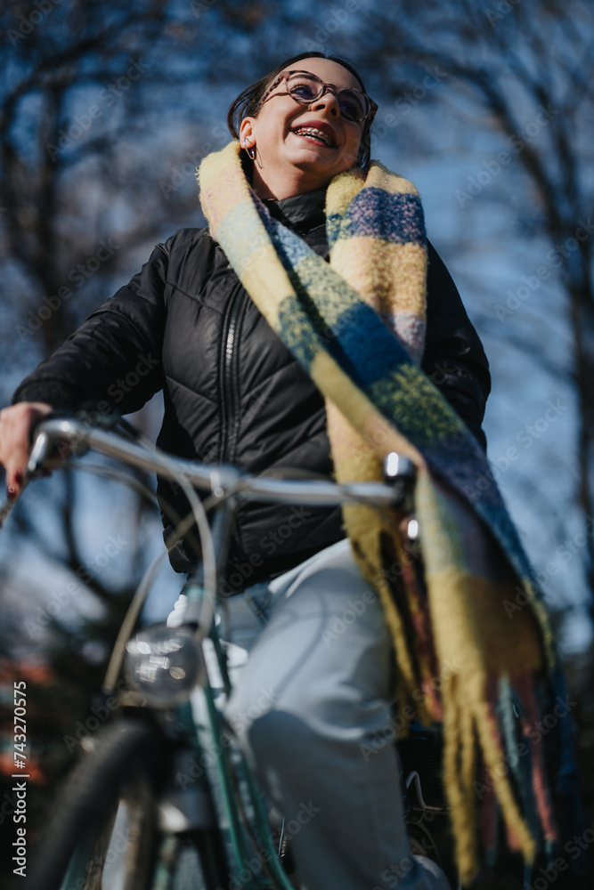 A woman with a radiant smile rides her bicycle in a park, the sunlight highlighting her cheerful disposition and the movement of her colorful scarf. A woman with a radiant smile rides her bicycle in a park, the sunlight highlighting her cheerful disposition and the movement of her colorful scarf.