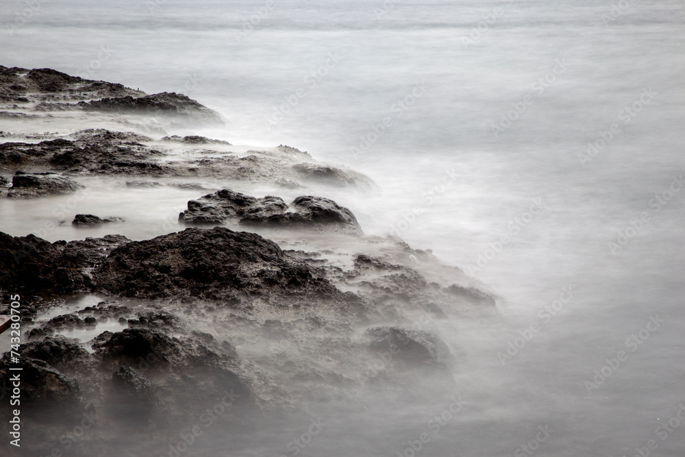 Long-exposure of the surf at the rocky seaside