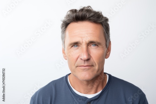 Portrait of mature man looking at camera with serious expression, isolated on white background