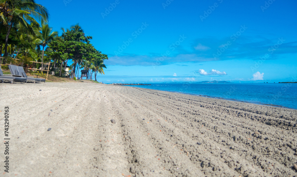 Fiji luxury resort beach blue sky and water a few white clouds