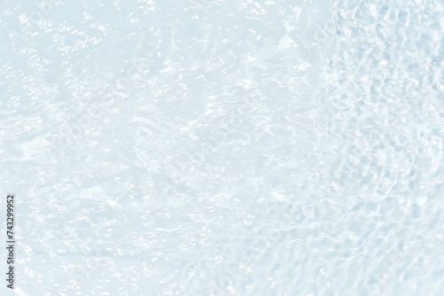 Blue water surface texture with ripples  splashes  and bubbles. Abstract summer banner background Water waves in sunlight with copy space cosmetic moisturizer micellar toner emulsion. Blue water wave.