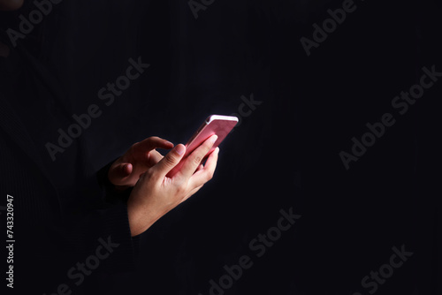 Businessman uses a mobile phone and types on the touch screen of a mobile phone Business concept with black background.