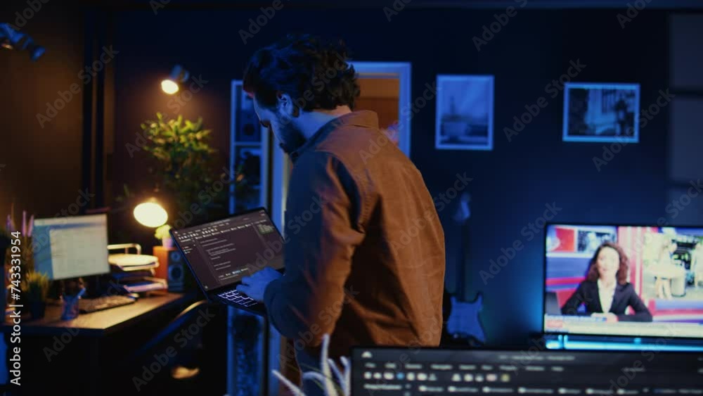 Man doing IT support job from home, walking around personal office with laptop in hand, coding. Nervous programmer wandering around room from stress, writing lines of code on notebook, camera B Man doing IT support job from home, walking around personal office with laptop in hand, coding. Nervous programmer wandering around room from stress, writing lines of code on notebook, camera B