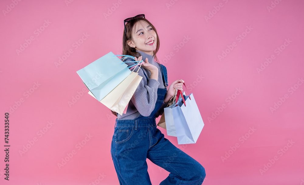 Portrait of happy beautiful shopaholic asian woman carry shopping bags, winter fashion sale model Asia girl with copy space, outlet department store advertising concept isolated pink banner background Portrait of happy beautiful shopaholic asian woman carry shopping bags, winter fashion sale model Asia girl with copy space, outlet department store advertising concept isolated pink banner background
