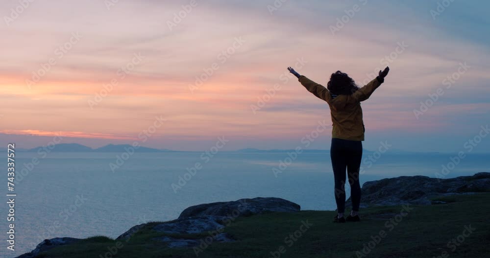 Back, sunset and happy woman with freedom for the hiking view on an active vacation to Norway. Mountain, success and carefree female person on the celebrate after a hike in nature by the coast Back, sunset and happy woman with freedom for the hiking view on an active vacation to Norway. Mountain, success and carefree female person on the celebrate after a hike in nature by the coast