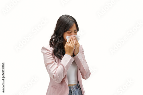 A sick young Asian woman standing on an isolated white background and sneezing with tissue paper. Female blowing nose, coughing, or sneezing in tissue. 