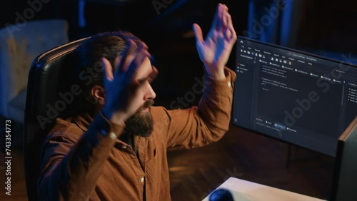 Outraged software engineer perplexed by impossible to remove bugs appearing while coding on computer desktop. Teleworking IT admin feeling baffled by script errors, putting hands on head, camera A