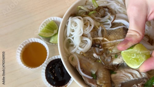 A young girl eats delicious pho bo soup with chicken in Vietnam in the mall fast cooking cheap food healthy traditional Vietnamese soup in Ho Chi Minh City. Saigon photo