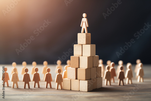 Conceptual Image of Leadership and Success with Wooden Figures on a Pyramid of Blocks